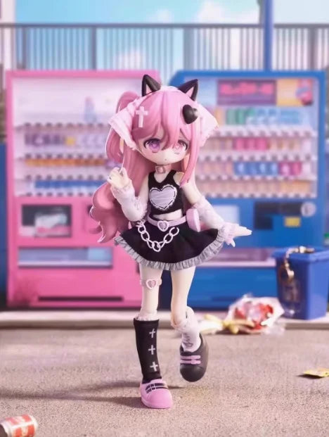 A pink-haired anime figure dressed in a black and white outfit stands in front of a colorful display box.
