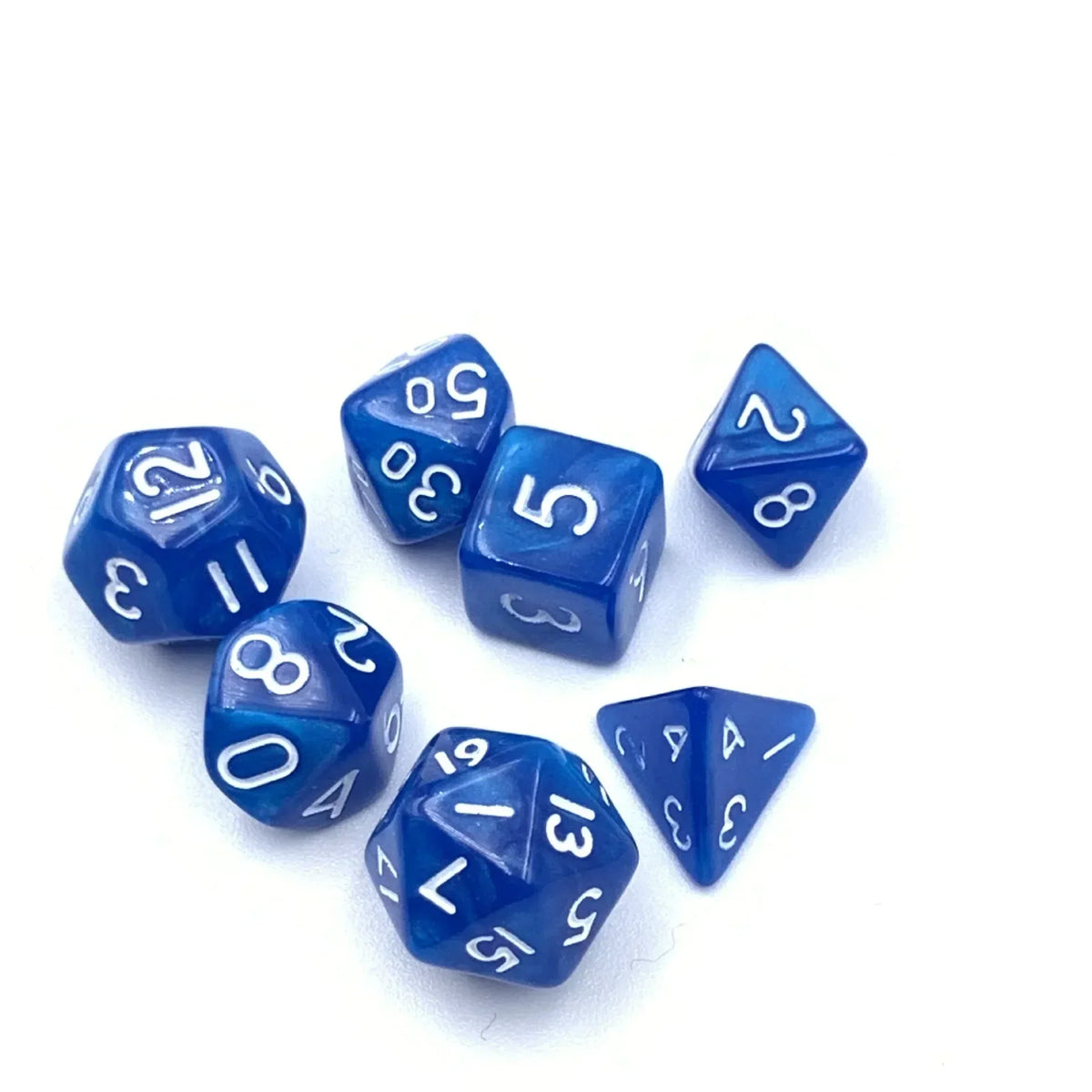 A collection of seven small blue polyhedral dice scattered on a white surface.
