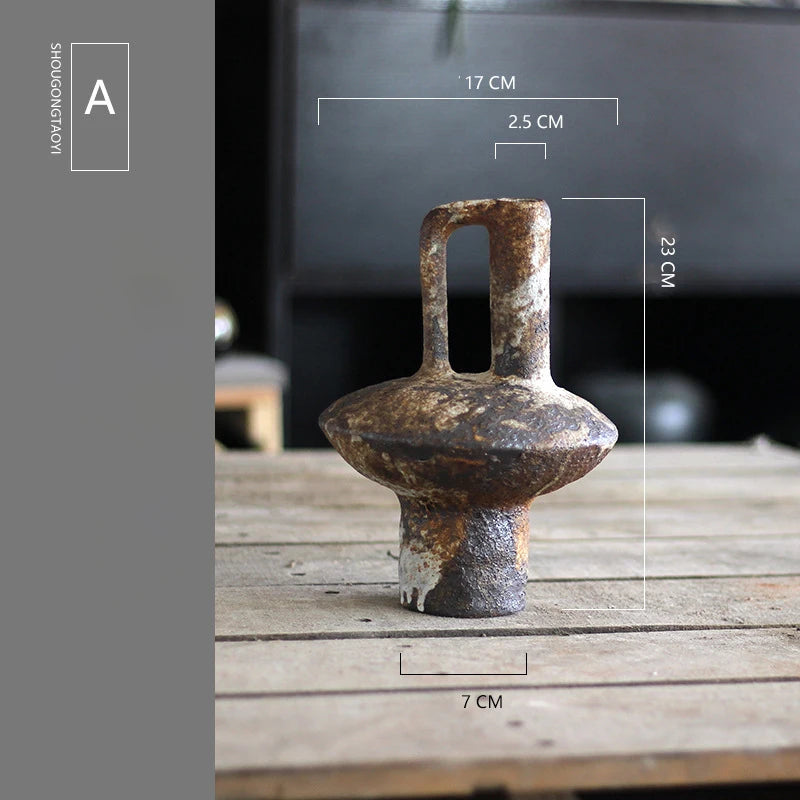 A vintage handcrafted ceramic vase with an elongated spout and handle sits on a wooden surface.