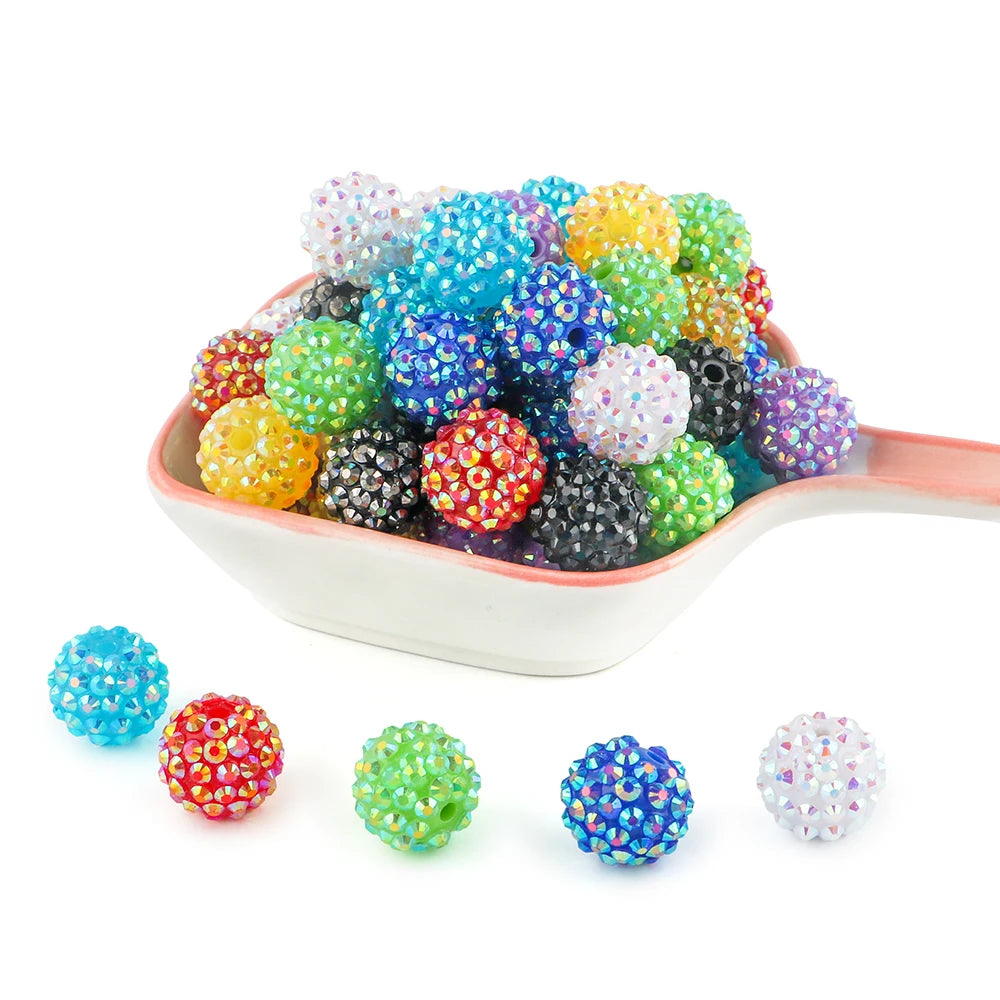 A pile of colorful rhinestone resin bayberry ball beads in various shades of blue, green, yellow, and purple.