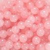 A close-up of pink glass round beads used for DIY jewelry making