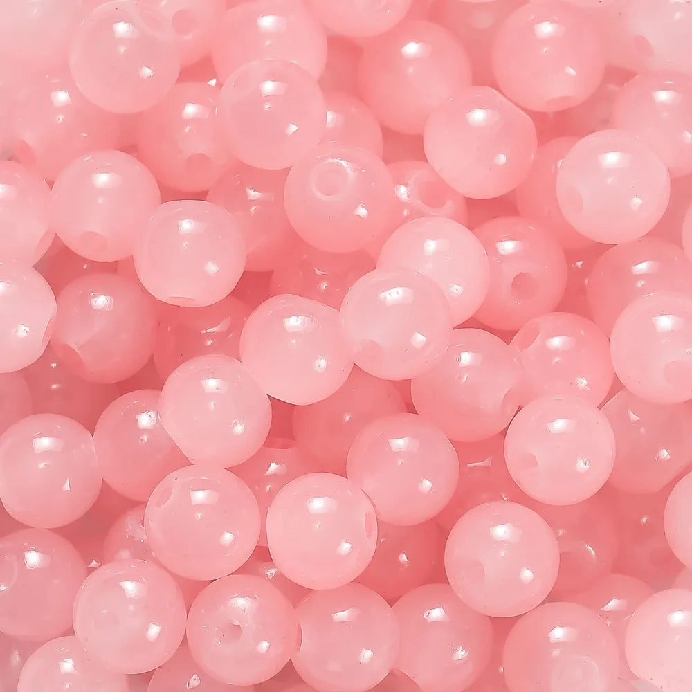 A close-up of pink glass round beads used for DIY jewelry making