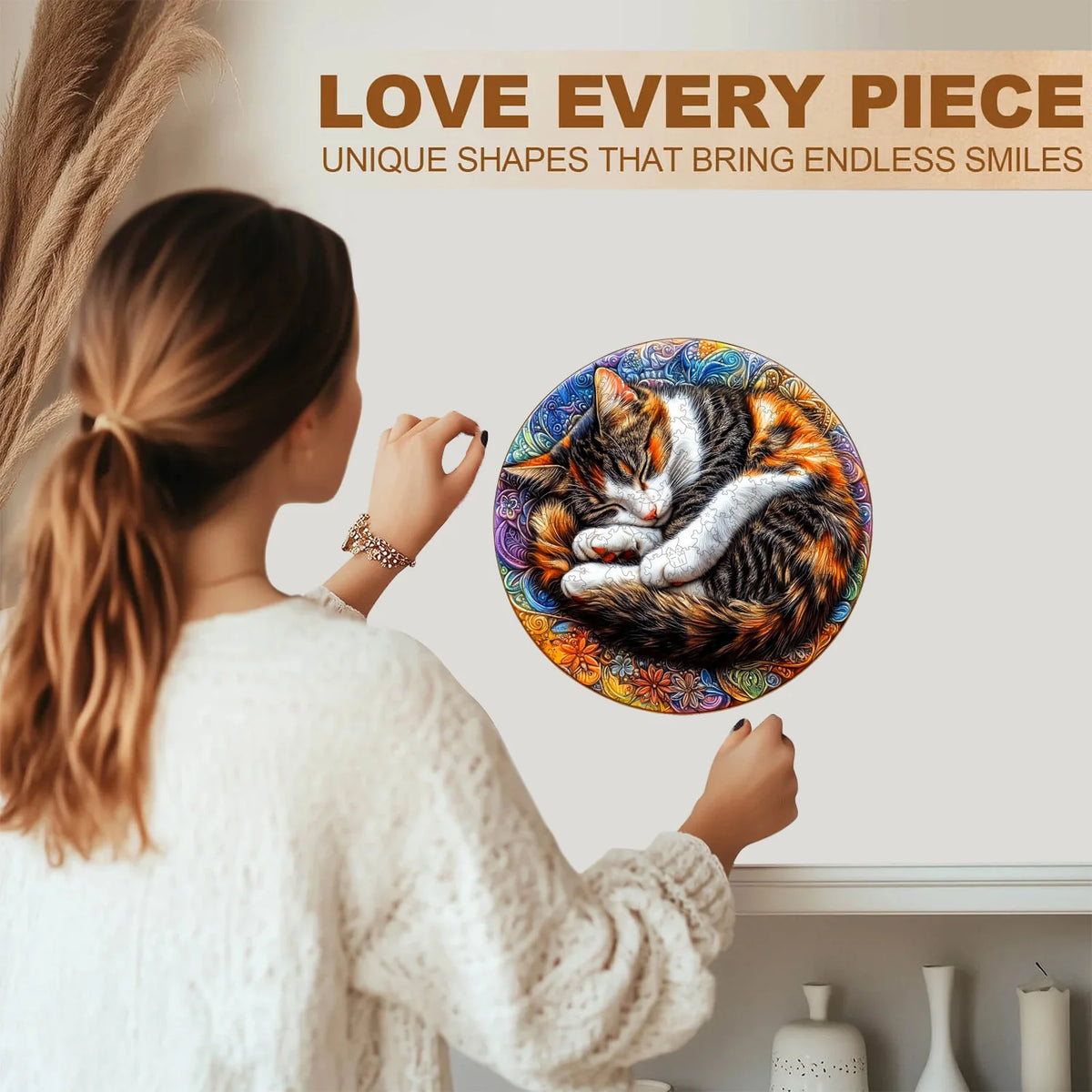 A woman holds up an animal wooden jigsaw puzzle featuring a cat with orange and black fur against a white background.