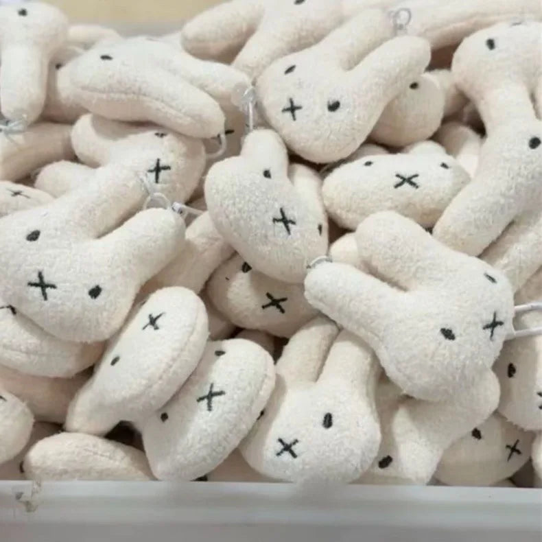 A pile of white Miffy cartoon rabbit keychain pendants