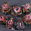 A set of seven liquid core resin polyhedral dice showing iridescent colors and numbers for tabletop gaming.