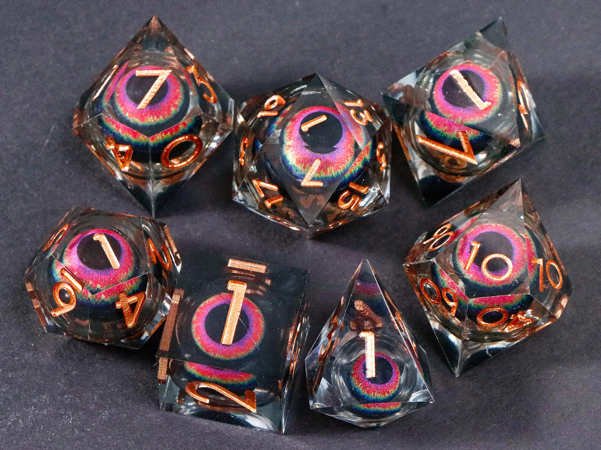 A set of seven liquid core resin polyhedral dice showing iridescent colors and numbers for tabletop gaming.