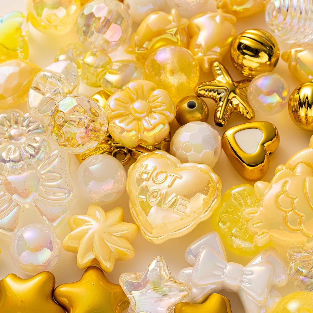 A close-up of various yellow and gold acrylic bow and flower beads for DIY jewelry making