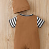 A brown baby romper and matching hat with black and white stripes displayed on a wooden surface.