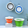 A set of colorful collapsible buckets with lids mounted on a wall and a separate orange and green bucket.
