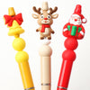 Three silicone beads shaped like a reindeer, a Christmas Santa, and a tree, used for festive craft jewelry.