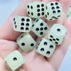 A hand holds a set of ten glow-in-the-dark dice, showing various sizes and translucent white dice.