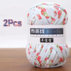A ball of white yarn with red floral patterns, labeled as soft chunky T-shirt yarn for crochet and knitting.