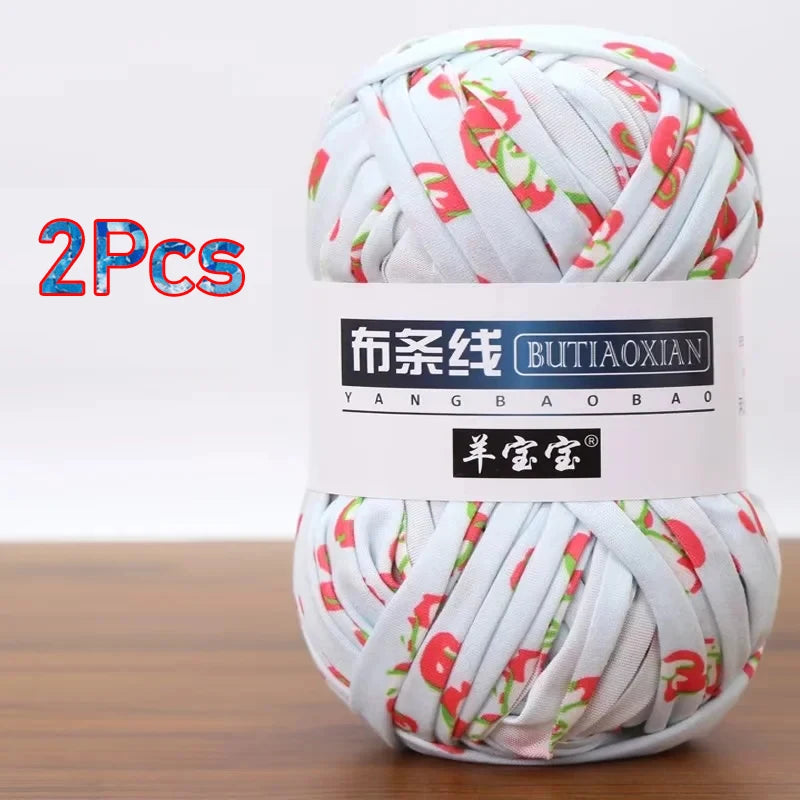 A ball of white yarn with red floral patterns, labeled as soft chunky T-shirt yarn for crochet and knitting.