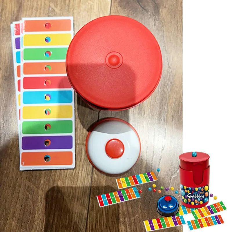 A red speed bead grabbing board game with a bell and colorful plastic beads laid out on a wooden surface.