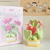 A pink box for a miniature flower bouquet building block set featuring green and pink floral elements.