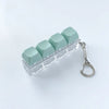 Clear acrylic fidget keychain with four light green clicky key buttons attached to a silver keyring