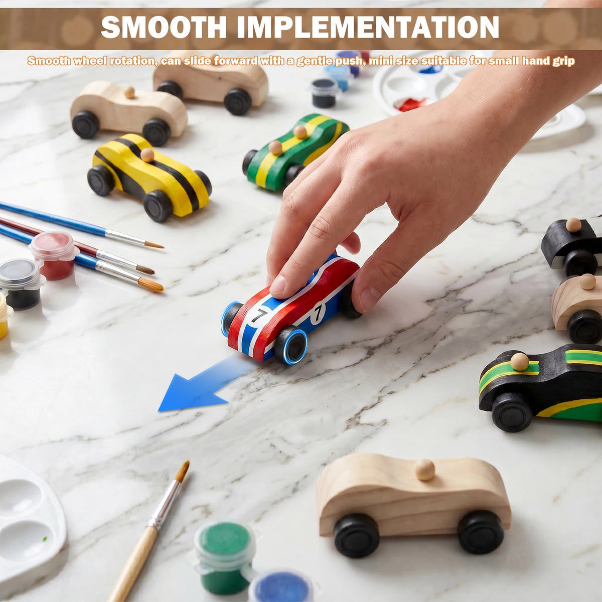 A hand gently pushes a red and white wooden race car across a marble surface among other wooden toy cars.