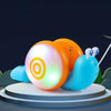 An orange and white musical pull-along snail toy is featured against a dark background.