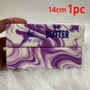 A rectangular bar of purple and white marbled butter soap is shown against a white fluffy background.