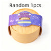 A yellow squishy dumpling stress relief toy with a purple glitter band.