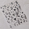 A collection of silver and black gothic nail art stickers featuring skulls, bats, stars, and hearts on a clear sheet.