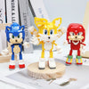 A set of three Kawaii dinosaur building block figures in blue, yellow, and red standing on a wooden base.