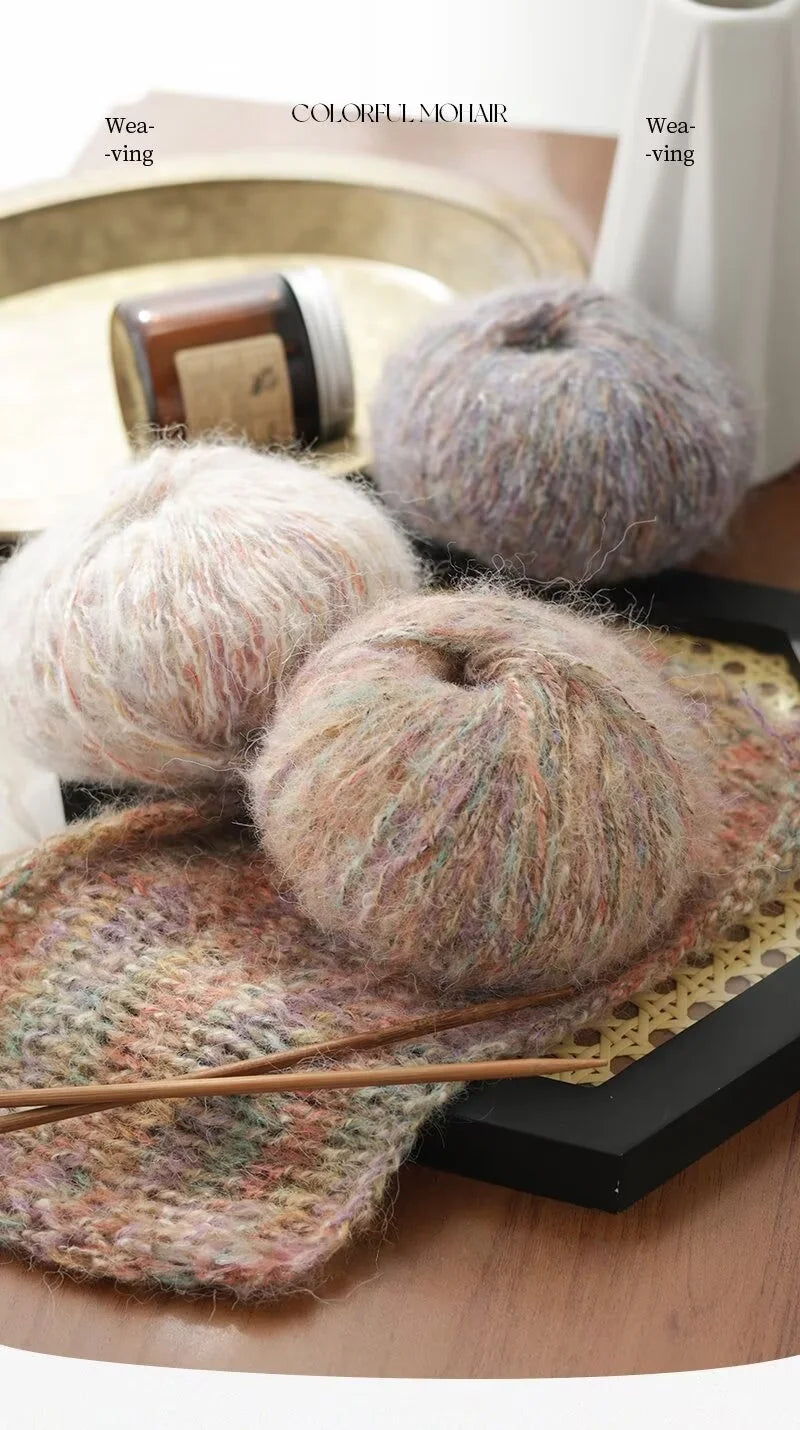 A close-up of colorful mohair yarn balls and a knitted item displayed on a wooden surface.