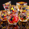 A close-up of a set of plum blossom liquid core resin dice with gold accents, reflecting on a dark surface.