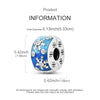 A silver heart charm with a blue enamel design featuring white floral elements and a central hole.