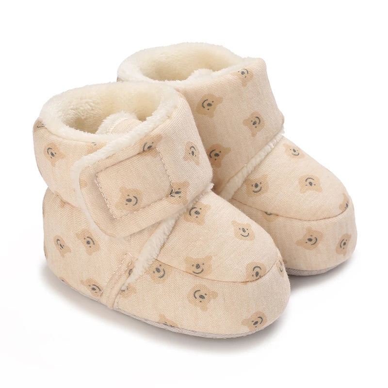 Pair of beige fuzzy baby winter cartoon boots with a soft non-slip sole