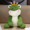 A cute green frog prince plush toy with a yellow crown and pink accents.