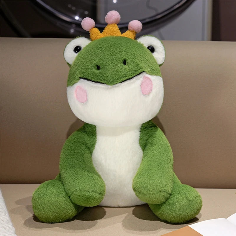 A cute green frog prince plush toy with a yellow crown and pink accents.