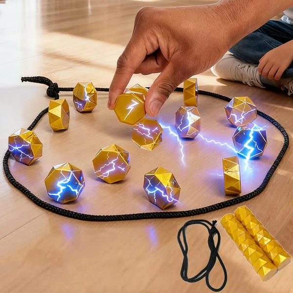 A hand places a yellow magnetic strategy game piece onto a black board with other glowing pieces.