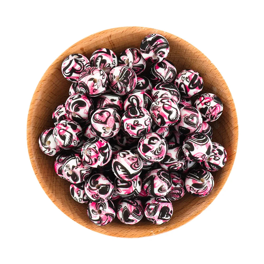 A wooden bowl filled with small, round, pink and black marbled silicone beads for jewelry making.