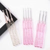 A set of seven aluminum crochet hooks with color-coded pink handles displayed on a white background.