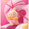 A pink Labubu vinyl plush pendant blind box with yellow accents and a heart shape.
