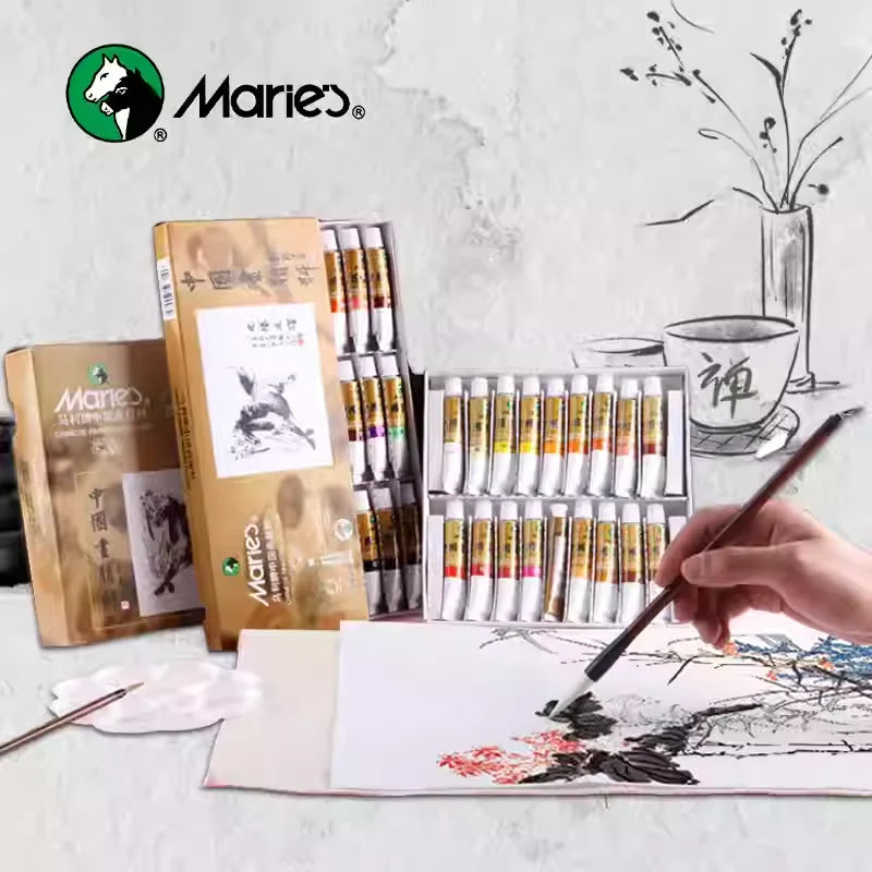 A set of Marie's Chinese painting pigments in glass tubes and wooden boxes is displayed next to a brush and paper.