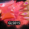 A hand holds a small plastic container of holographic rainbow nail glitter with fine sparkle dust scattered on a dark surface