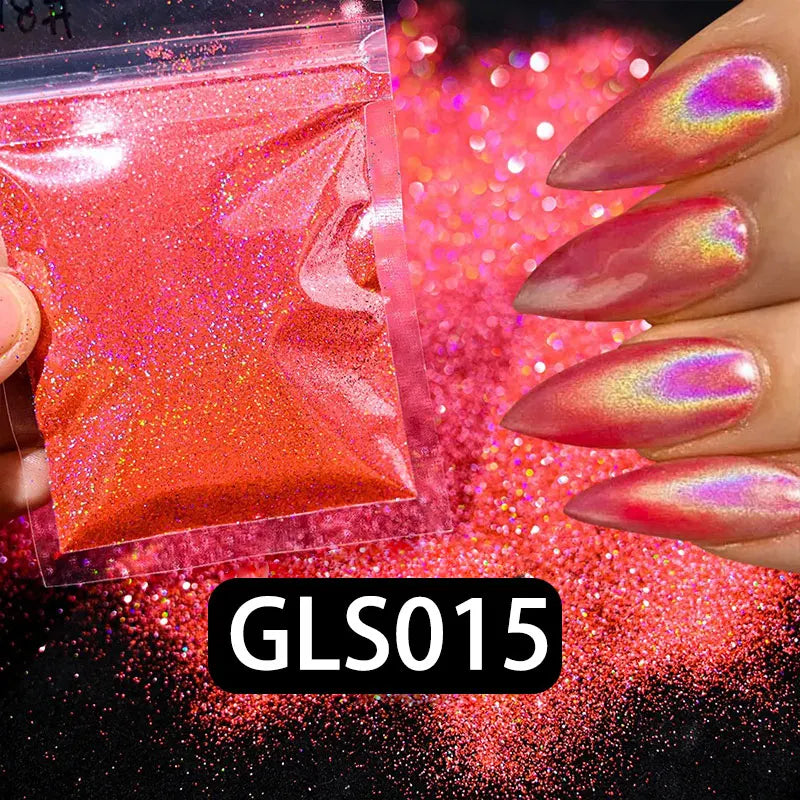 A hand holds a small plastic container of holographic rainbow nail glitter with fine sparkle dust scattered on a dark surface