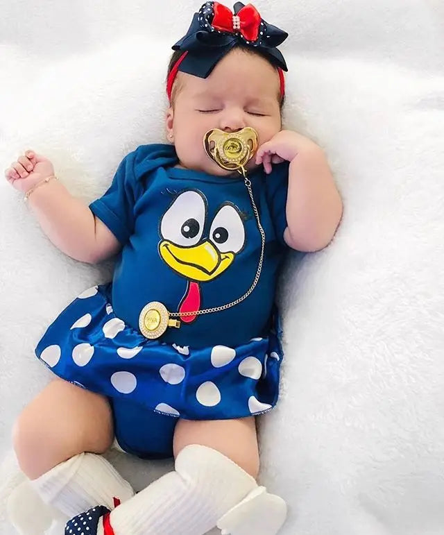 A baby wearing a blue and white bird costume outfit with a rhinestone pacifier and clip set