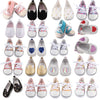 A collection of unicorn themed pajama shoes and slippers for dolls in various colors and styles.