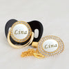 Gold and white bling pacifier clip featuring the name Lina on a black and gold design