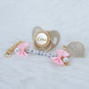 Personalized crystal pacifier with a pink ribbon and matching clip featuring the name Lina