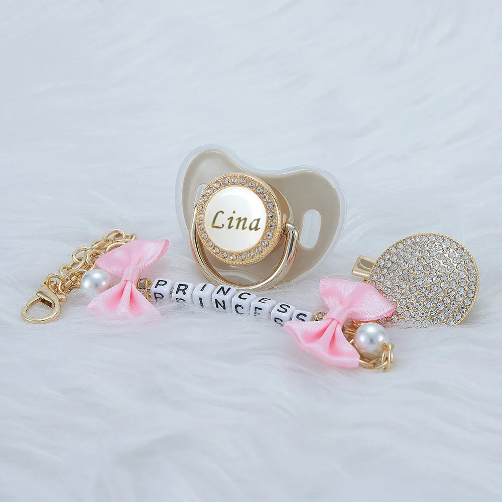 Personalized crystal pacifier with a pink ribbon and matching clip featuring the name Lina