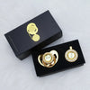 A black box containing a personalized crystal pacifier and clip gift set with gold accents.