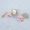 A personalized crystal pacifier featuring the name Lina, set with gold accents and a matching clip.