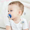 A baby is shown with a blue bling evil eye pacifier and clip set on their breast.