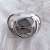 Silver silicone pacifier with a rounded top resting on white fluffy fur